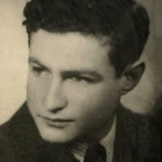 Black-and-white photograph of a young man's profile, looking towards the left of the camera. He wears a suit and has curly dark brown hair.